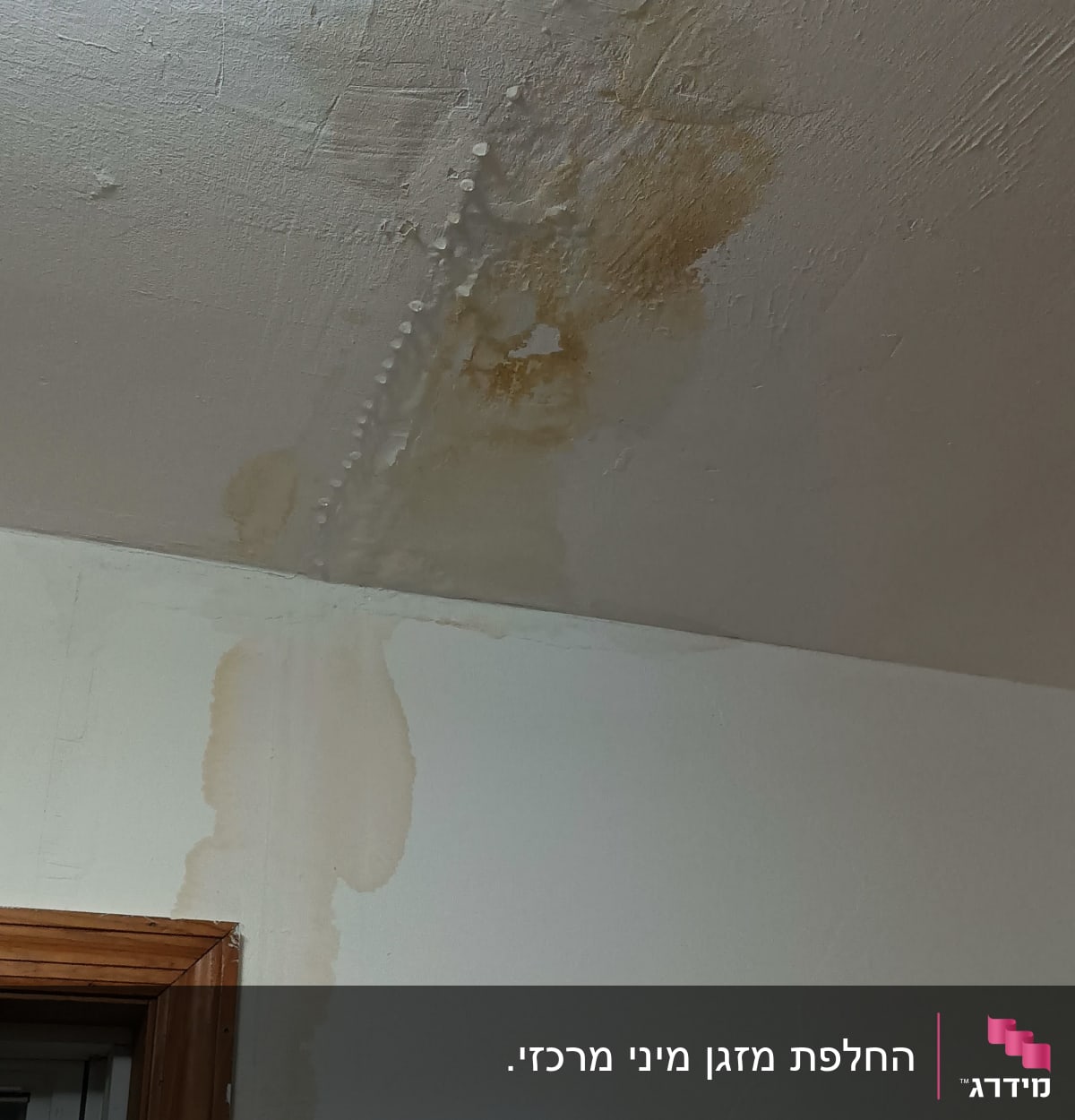 כתמי רטיבות על תקרה וקיר ליד חלון